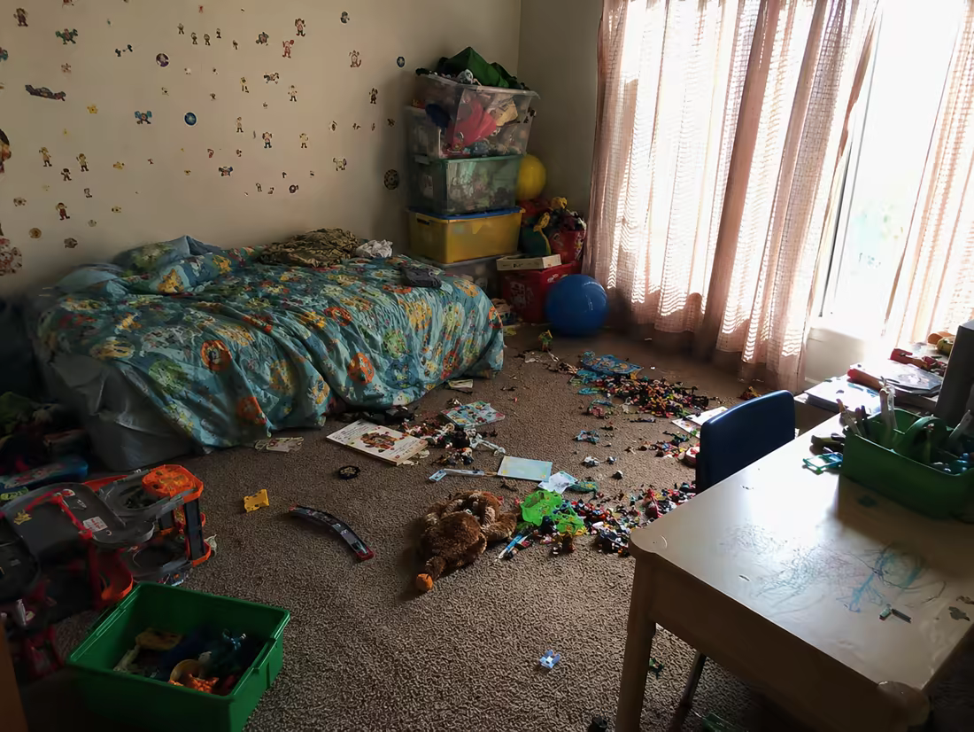 A chaotic kids room with toys covering the floor